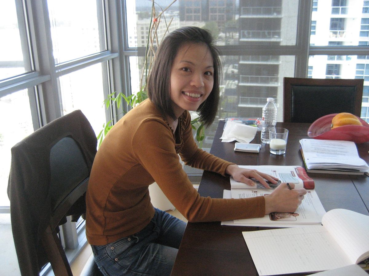 A student working through English study materials at a table during a tutoring session